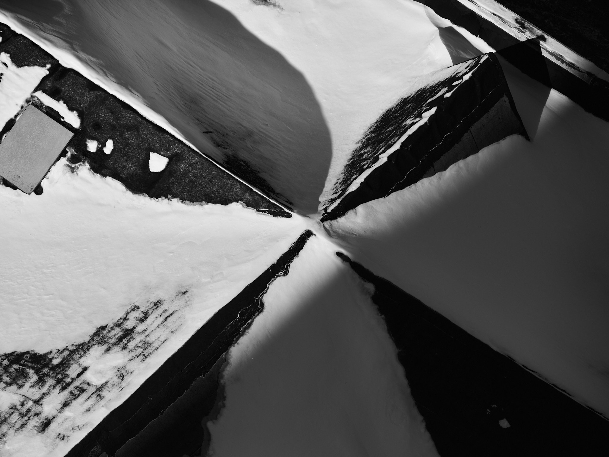 Snow-covered rooflines converging toward a dark central point