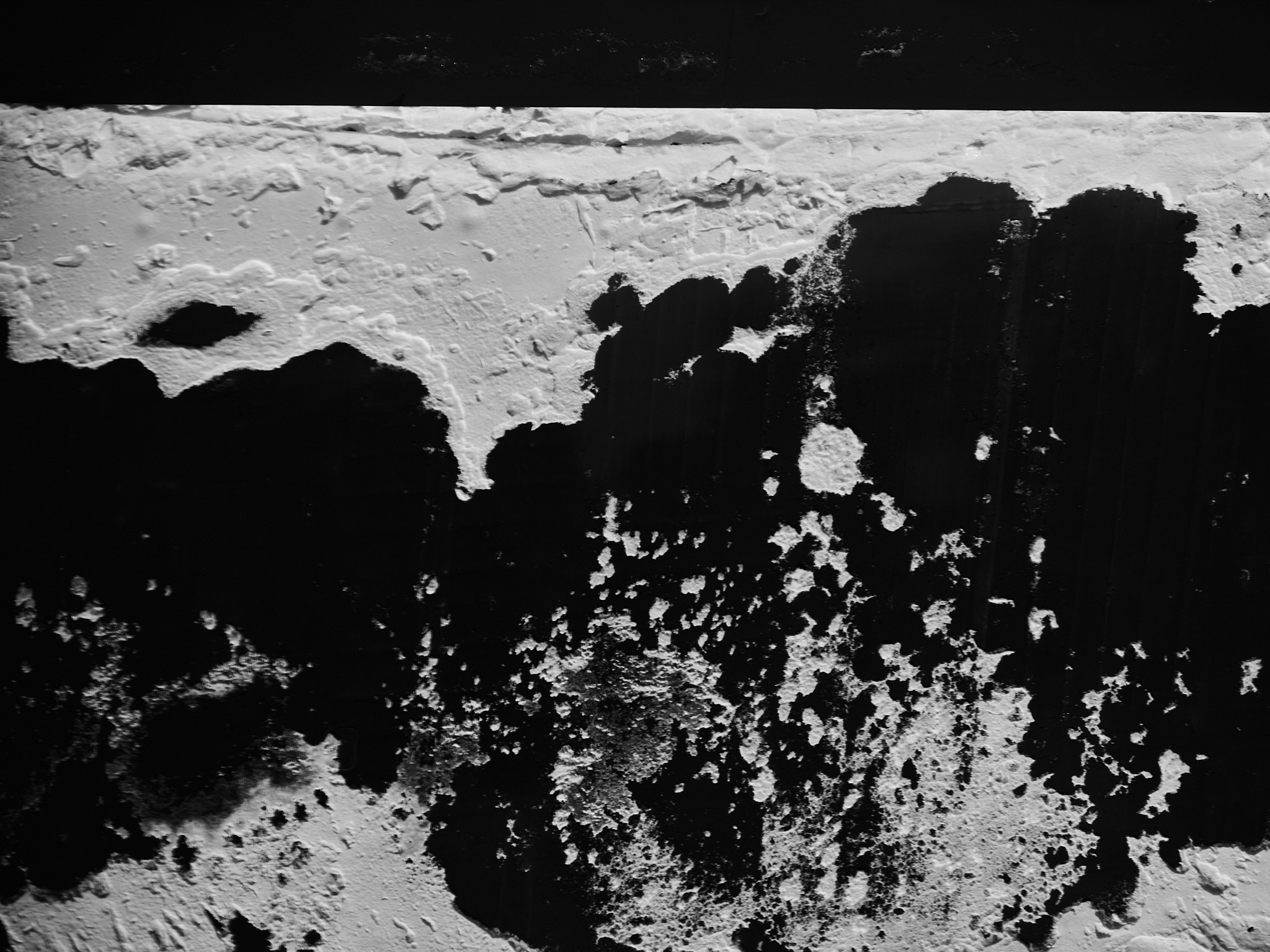 Stark white snow crust against deep black ground